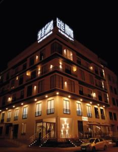 マチャラにあるREEC Machala by Oro Verde Hotelsの夜間の看板のある建物