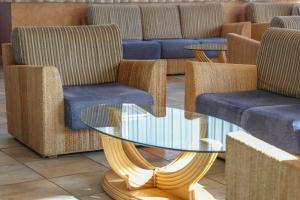 a glass table with two chairs and a couch at KAKTUS Hotel Kaktus Albir in Albir