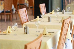 a group of tables with wine glasses and napkins at KAKTUS Hotel Kaktus Albir in Albir