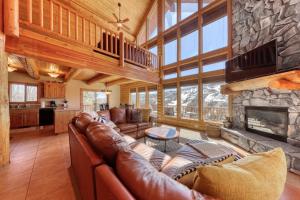 a living room with leather furniture and a stone fireplace at Ski-View Lodge in Brian Head