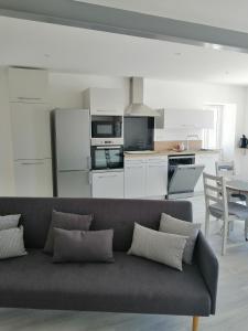 a living room with a couch and a kitchen at Maison de campagne "Beun'aise" in Val-du-Mignon