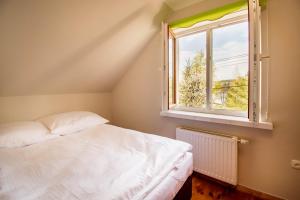 a bedroom with a white bed and a window at Dom z widokiem na jezioro Tajty - Wilkasy Zalesie in Giżycko