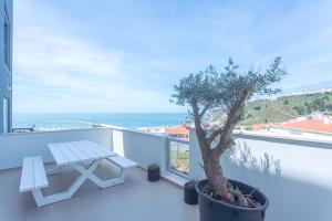 a picnic table on a balcony with a tree on it at Apartamento T2 Tin Tin in Nazaré