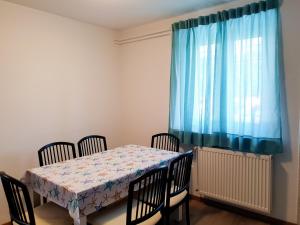 a dining room table with chairs and a blue curtain at APARTMA NANA STRUNJAN in Portorož