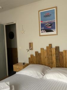 a bedroom with a bed and a poster on the wall at Hôtel la petite auberge in Arès +3 photos