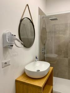 a bathroom with a white sink and a mirror at Enjoy Olbia in Olbia +15 photos