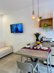 a kitchen with a table and a tv on the wall at Enjoy Olbia in Olbia