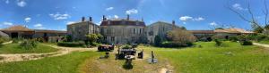 an old house with a grassy yard in front of it at Eco Logis de Chantegrolle in Champagne-Mouton