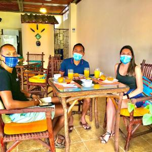 a group of people sitting at a table wearing masks at Casa del Lago Lodging House in Puerto Ayora