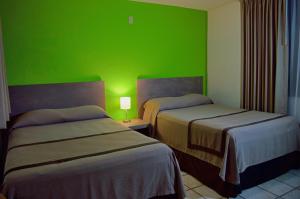 Postel nebo postele na pokoji v ubytování Sunrock Hotel & Suites