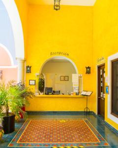un edificio con una pared amarilla y un suelo amarillo en Hotel Casa de las Flores, en Playa del Carmen