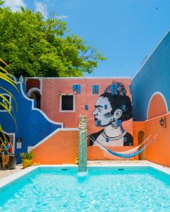 una piscina con una pintura en el lateral de un edificio en Hotel Casa de las Flores en Playa del Carmen