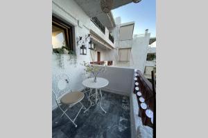 een kamer met een tafel en stoelen op een balkon bij RUSTIC DIAMOND new apartment near the beach in Porto Rafti