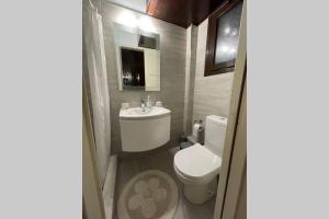 een badkamer met een wit toilet en een wastafel bij RUSTIC DIAMOND new apartment near the beach in Porto Rafti