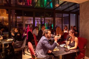 a group of people sitting at tables in a restaurant at Paris j'Adore Hotel & Spa in Paris +61 photos
