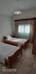 dwa łóżka w pokoju z oknem w obiekcie Achille's apartment w mieście Plataria