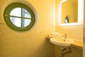 a bathroom with a sink and a round window at Ferienhaussiedlung Strandperlen Buchenhof 6a (Typ III) in Wustrow