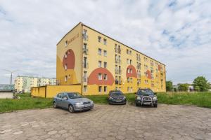 three cars parked in front of a yellow building at Hello Apartments Dworska LIGHT in Gdańsk