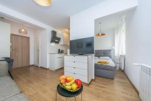a living room with a bowl of fruit on a table at Hello Apartments Dworska LIGHT in Gdańsk