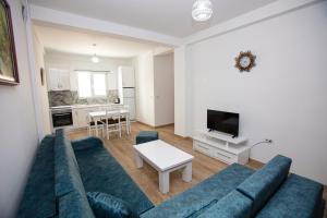 - un salon avec un canapé bleu et une table dans l'établissement Korca Apartments, à Korçë