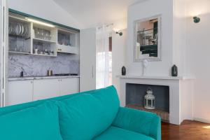 sala de estar con sofá azul y chimenea en Maison Contrari, en Ferrara
