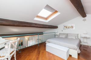 a attic bedroom with a bed and a desk at Maison Contrari in Ferrara