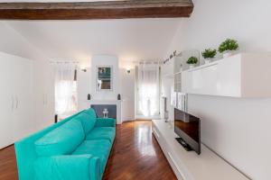 un soggiorno con divano blu e TV di Maison Contrari a Ferrara