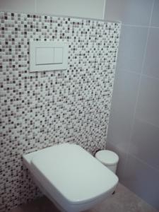bagno con servizi igienici bianchi e parete piastrellata di Apartmán Pri Jazere - Slnečné jazerá JUH a Senec