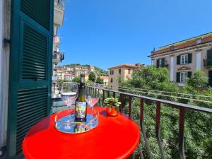 a red table with wine glasses on a balcony at SONI APARTMENT in La Spezia