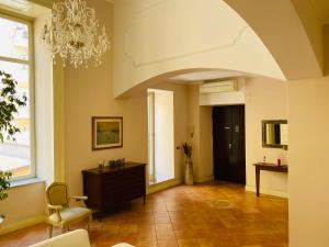 - un salon avec un lustre, une table et une chaise dans l'établissement Ambra Noblesse, à Naples