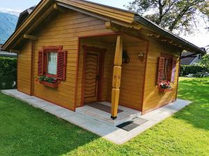 Cabaña de madera pequeña con puerta y ventanas en Ferienhaus Mentil en Greifenburg