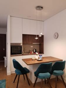a kitchen with a wooden table and blue chairs at Azura Residence - new luxury apartment in Belgrade