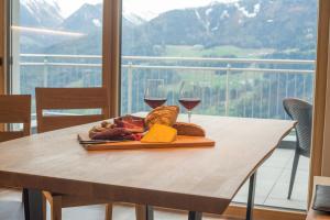 Jaufnerhof في Mareta: طاولة مع طبق من الطعام وكأسين من النبيذ