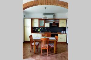 uma cozinha com uma mesa de jantar e cadeiras em L' Agave - Appartamento nel cuore del Chianti em Castelnuovo Berardenga