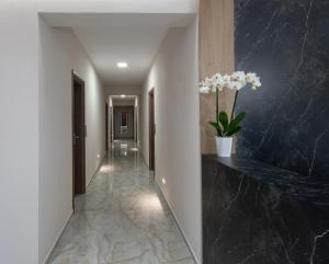 a hallway with black marble flooring and a hallway with a vase of flowers at VagAthan - Lux Holidays in Afitos