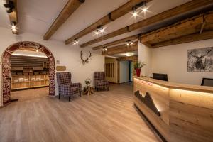 a lobby with a waiting room with chairs and a counter at Alpenhotel Brennerbascht in Bischofswiesen