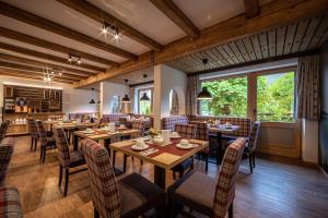 a dining room with wooden tables and chairs at Alpenhotel Brennerbascht in Bischofswiesen