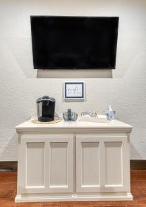 un armadio bianco con lavandino e TV a schermo piatto di Bluebird Inn Elk City a Elk City