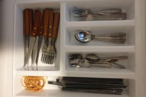 un tiroir blanc rempli d'ustensiles, de fourchettes et de cuillères dans l'établissement @Mojo Smart Apartment - Begawan Apartment, à Dau