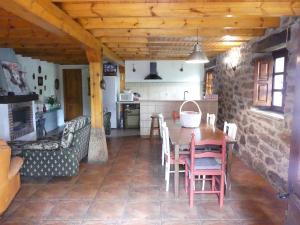 cocina y comedor con mesa y sillas en Cabaña pasiega Las Lugas, en Liérganes