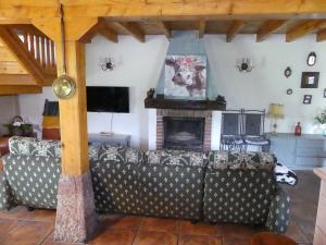 sala de estar con sofá y chimenea en Cabaña pasiega Las Lugas, en Liérganes