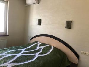 1 dormitorio con 1 cama con edredón verde y blanco en дача en Odesa