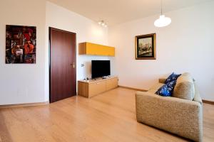 Skyline Apartment في ميلانو: غرفة معيشة بها أريكة وتلفزيون