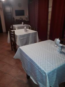 two tables with white table cloths in a room at Villa enza in Cinisi