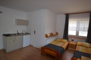 a bedroom with a bed and a kitchen with a sink at Dom Gościnny Przystań in Międzywodzie