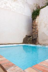 uma piscina numa casa com uma parede de pedra em La Pileta em Vejer de la Frontera