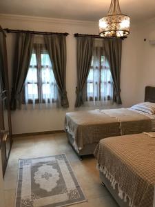 a bedroom with two beds and a chandelier at Castello Marmaris Holiday Home in Marmaris