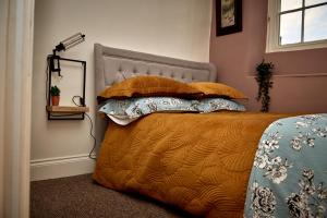 a bedroom with a bed with pillows and a lamp at Maltings Cottage in Barnard Castle