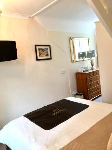 a bedroom with a bed with a black blanket on it at Rosalie Guest House in Penzance