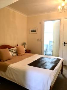 a bedroom with a large bed and a window at Rosalie Guest House in Penzance